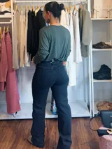 Jean negro de corte recto y tiro alto, con doble lycra y costuras en color beige.
