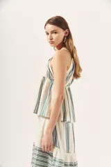 Top blanco con estampado de líneas verticales en verde y escote halter con tirantes finos.