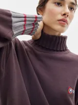 Pullover de punto verde con cuello tortuga, corte oversize y puños ajustados, con banderín insignia de la marca.