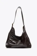Bolso maxi shopper color marrón oscuro, con asa ancha ajustable con hebilla. Incluye bolsillo interno con cierre de cremallera metálica y cierre imantado.