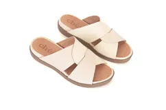 Sandalias de cuero color crema con tiras cruzadas y plantilla anatómica.