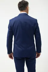 Ambo azul marino de corte clásico, compuesto por saco de dos botones con solapa de muesca, bolsillo de pecho y dos bolsillos delanteros con solapa, y pantalón de vestir con pinzas y bolsillos laterales y traseros.