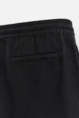 Bermuda negra regular fit confeccionada en tejido de algodón con estructura. Cintura elástica ajustable con cordón, bolsillos laterales y bolsillo trasero de vivo.