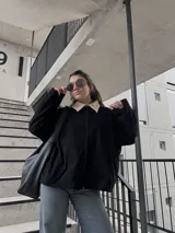 Campera negra de pana con cuello beige, cierre frontal y bolsillos laterales.