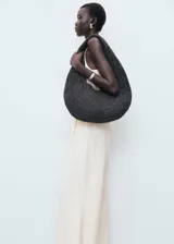 Mono largo color crudo, con escote halter, sin mangas, con cierre de botones frontal y cinturón tipo lazo en la cintura.