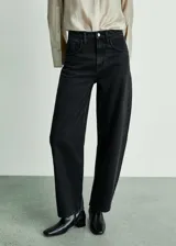 Pantalón de jean negro de corte slouchy, tiro alto, cinco bolsillos, cierre de cremallera y botón.