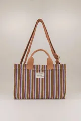 Mini bolso tote de algodón a rayas verticales marrones, azules y blancas, con doble asa de mano marrón y correa de hombro ajustable marrón.