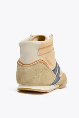 Zapatilla deportiva tipo botín color beige con detalles en azul marino y naranja.