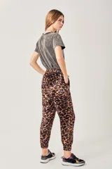 Pantalón babucha de terciopelo con estampado de leopardo en tonos marrones y negros, con cintura y tobillos elastizados.
