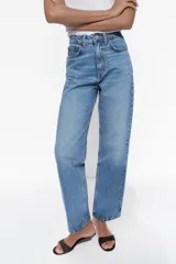 Pantalón de jean celeste de tiro alto, corte recto, con cinco bolsillos y cierre frontal con cremallera y botón metálico.