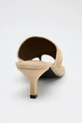 Sandalia tipo mule color beige, de ante, con tacón fino medio y tira ancha con efecto arrugado.