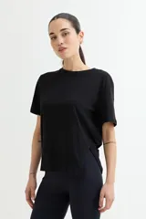 Remera negra de algodón con cuello redondo y mangas cortas. Presenta un tajo lateral en el ruedo.