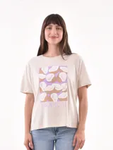 Remera color crudo con estampado de cocos sobre un fondo lila y la palabra 'Tropical' en la parte inferior.