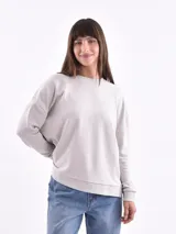 Sweatshirt color gris claro, de corte holgado y mangas largas.