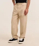 Pantalón baggy negro de sarga de algodón, con cintura fija con trabillas, botón contrastante y cierre por cremallera oculto, bolsillos laterales y traseros. Modelo holgado de corte recto y ancho.