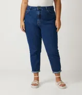 Pantalón mom jeans azul oscuro, tiro alto, con bolsillos delanteros y traseros, trabillas en la cintura, cierre frontal con botón y cremallera, y dobladillo doblado.