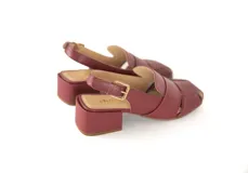 Sandalia de cuero color borgoña, con punta cuadrada y tiras anchas entrecruzadas. Tiene talón abierto con pulsera ajustable y taco ancho forrado de 4 cm.