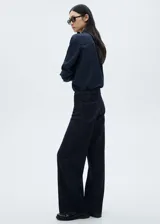 Pantalón de jean azul oscuro, corte wide leg, tiro medio y largo hasta el tobillo. Incluye cinturón con hebilla y cuatro bolsillos.