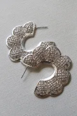 Aros plateados con forma de flor calada.