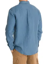Camisa de manga larga azul con cuello clásico, cierre con botones y bolsillo en el pecho.