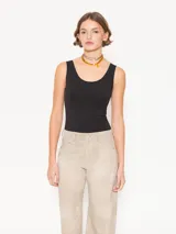 Musculosa negra de algodón pima orgánico, de calce al cuerpo y terminaciones al corte.