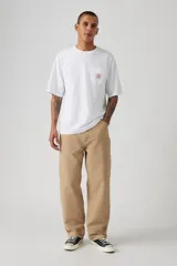 Pantalón de trabajo color beige, de corte recto y holgado, con bolsillos laterales y traseros.