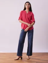 Blusa color rosa de lino marca Cupio, con cuello a la base, escote en V y abertura con botones. Tiene un bolsillo en la parte delantera y mangas 3/4 regulables con presilla y botón.