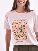 Remera color amarillo claro con estampado de limones, hojas y flores en tonos verdes y grises.