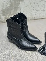 Bucaneras negras de cuero con caña alta y flecos desmontables.