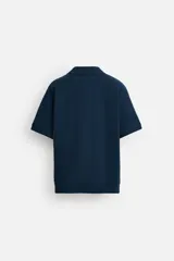 Polo azul marino de punto con textura acanalada vertical, corte regular fit, cuello solapa con abertura frontal y mangas cortas.