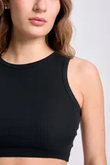 Musculosa corta negra de tejido de punto acanalado, con cuello redondo y sisas amplias.