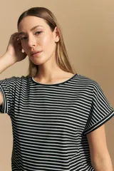 Remera de manga corta con cuello redondo, confeccionada en tejido acanalado a rayas horizontales blancas y negras.