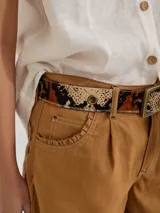 Bermuda color marrón claro, de tiro medio/alto, calce cómodo y relajado, con detalle de voladito en bolsillos.