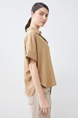 Camisa color pistacho de lyocell con cuello clásico, cierre frontal con botones y mangas cortas.