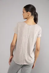 Remera blanca de poliéster y algodón, con escote en V, corte relajado, bordes sin rematar, detalles de costura central expuesta y dobladillo estilo camisero.