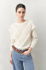 Sweater color crema de punto liso con detalle de crochet en el escote y en forma de pico sobre el pecho.
