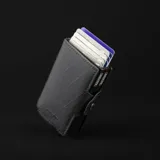 Billetera doble de tela X-Pac negra con doble caja de aluminio incorporado con sistema de deslizamiento para tarjetas. Tiene espacio para 10 tarjetas, 2 tarjetas adicionales en los bolsillos laterales de cuero, espacio para libreta de conducir y de propiedad, y sección interna para llevar hasta 5 billetes.
