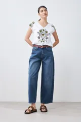 Remera blanca de algodón con escote en V y estampado floral en el frente y los hombros.