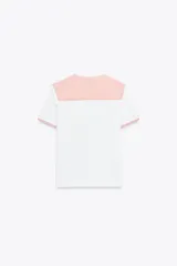 Camiseta blanca de cuello bobo con terminaciones bordadas y detalle de lazo en el delantero. El cuello y las mangas cortas son de tela a cuadros vichy color salmón.