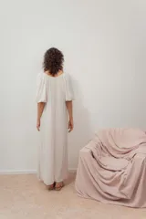 Vestido midi color crudo, de corte suelto, con escote en V y mangas abullonadas.