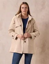 Gabardina impermeable color beige, marca Weatherproof, con abertura central con botones, bolsillos delanteros y capucha desmontable.