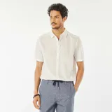 Camisa blanca de manga corta con cuello clásico y estampado de hojas.