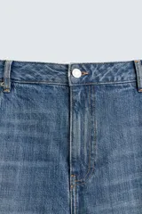 Pantalón de jean azul de corte amplio, con roturas y lavado gastado.