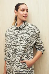Sobrecamisa de calce amplio con estampado animal print, cuello camisero, cierre con botones, bolsillos frontales y ruedo redondeado.