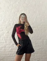 Top de microtul negro con estampado de flor roja.