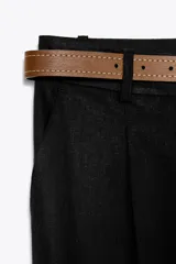 Pantalón blanco de lino, de tiro alto con pinzas delanteras, bolsillos frontales y falsos bolsillos con solapa en la espalda. Incluye cinturón marrón.