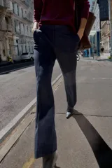Pantalón de vestir azul marino, de tiro medio, con bolsillos delanteros y falsos bolsillos de vivo en la espalda. Pierna recta y acampanada.