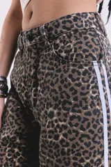 Pantalón de jean de corte ancho con estampado animal print y rayas blancas laterales.