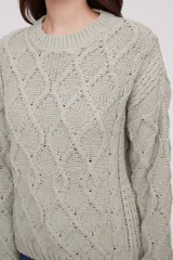 Sweater de punto color mostaza, con diseño de trenzas y puños acampanados.