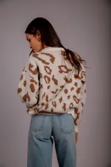 Sweater de punto color crudo con estampado animal print marrón.